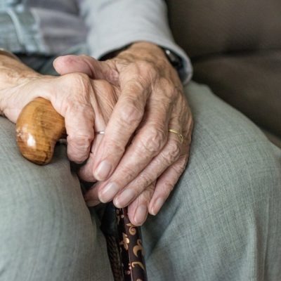 Elderly person holding a walking stick